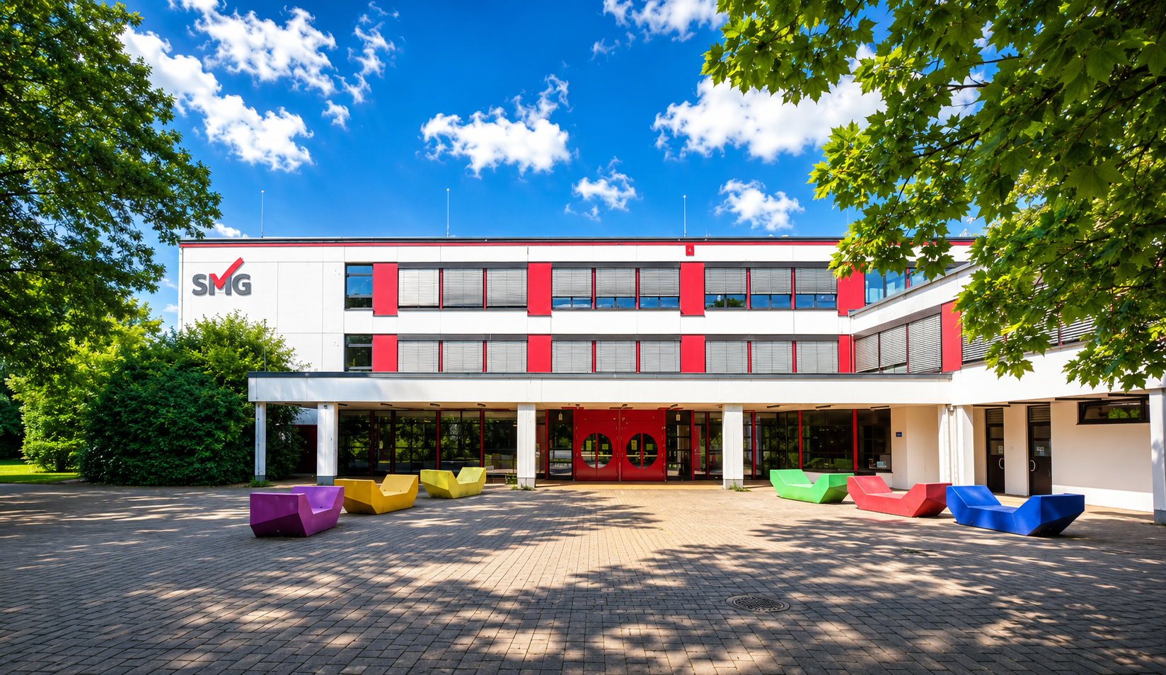 Vorderansicht des Städtischen Meerbusch-Gymnasiums mit Schulhof und Haupteingang
